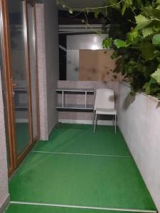 a green floor in a room with a chair on it at Casa Ala in Cahul