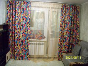a living room with two curtains and a window at Апартаменты на Серебровской in Tula