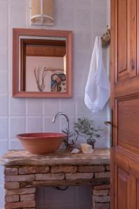 ein Bad mit einem Waschbecken und einem Spiegel in der Unterkunft AMNISIADES APARTMENTS in Karteros