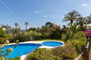 a swimming pool in a garden with flowers at BELLA GADEA in Altea