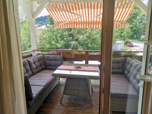 a screened in porch with a couch and a table at Ankommen und loswandern Familien und Hundeurlaub im Hochschwarzwald Ferienwohnung Haus Maria in St. Blasien