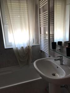 bagno con lavandino, vasca e finestra di L'Alloggio Perfetto a Putignano