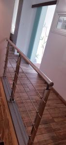 a staircase with a metal rail and wood floors at Butterfly Bedroom in Sweet Home in Aimargues