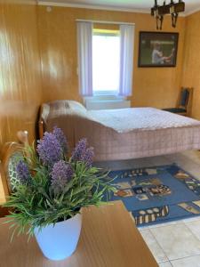 1 dormitorio con cama y mesa con flores púrpuras en Constancia, en Kamianets-Podilskyi