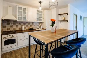 a kitchen with a wooden table and two blue bar stools at Family dream house in Ružić
