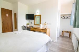 a bedroom with a bed and a desk and a mirror at The Residence @ Jaipur in Easingwold