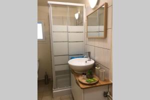 ein Bad mit einem Waschbecken und einem Spiegel in der Unterkunft Studio Cosy 2 PERS in Longjumeau