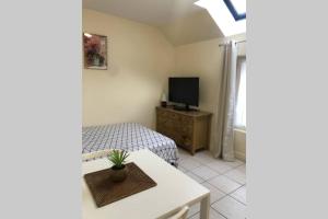 ein kleines Schlafzimmer mit einem Bett und einem TV in der Unterkunft Studio Cosy 2 PERS in Longjumeau