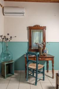 Zimmer mit einem Tisch, einem Stuhl und einem Spiegel in der Unterkunft AMNISIADES APARTMENTS in Karteros