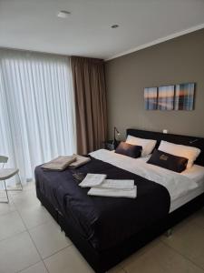 een slaapkamer met een groot bed en handdoeken bij BONNIES Beach & Spa DuinNest in Cadzand-Bad