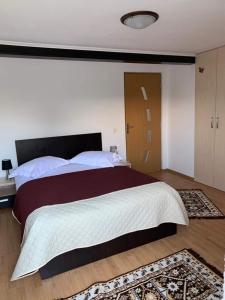 - une chambre avec un grand lit et une tête de lit en bois dans l'établissement Casa din Grădină, à Moieciu de Jos