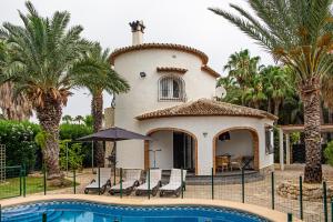 a villa with a swimming pool in front of a house at Villa Helene in Miraflor