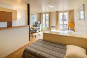 パリにあるHôtel Capfun Le Saint Germain, Parisのベッドと机があるホテルの部屋 +17枚の写真