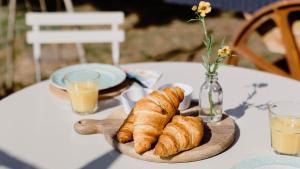 uma mesa com um prato de croissants e sumo de laranja em Stamford Cider Huts em Stamford