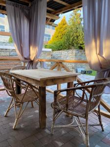 a wooden table and chairs on a patio at Constancia in Kamianets-Podilskyi