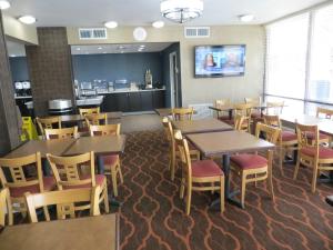 Baymont Inn & Suites by Wyndham Florence في فلورنسا: غرفة طعام مع طاولات وكراسي في مطعم