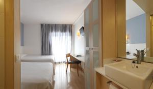 
a hotel room with a bed and a mirror at Hotel Guitart Central Park Aqua Resort in Lloret de Mar
