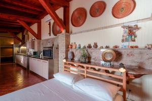 a bedroom with a bed and a kitchen with plates on the wall at Cedri 14 in Capitana