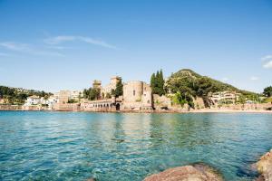 a castle on the shore of a body of water at LesJardinsFleuris in Mandelieu-La Napoule