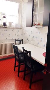 una cucina con tavolo bianco e 2 sedie di Ferienwohnung Kochel mit Wallbox a Gifhorn