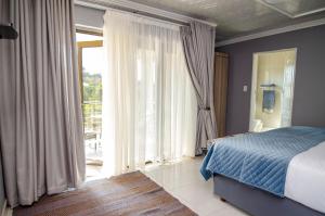 a bedroom with a bed and a large window at House of Sollys Guesthouse in Manamane