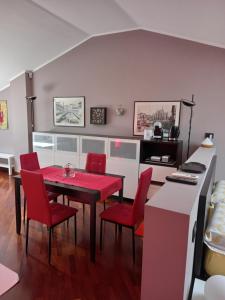 ein Esszimmer mit einem roten Tisch und Stühlen in der Unterkunft La mansarda di Mi&Lo junior suite in Bollate