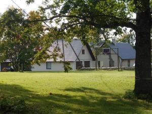 uma grande casa branca com uma árvore no quintal em Nurmeveski Holiday House em Nurme