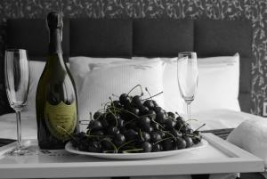 a plate of grapes on a table with a bottle of wine at Alex Palace in Dziwnów