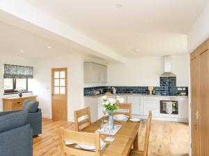 uma cozinha e sala de estar com uma mesa e um sofá em Bwthyn Cae Haidd em Beaumaris