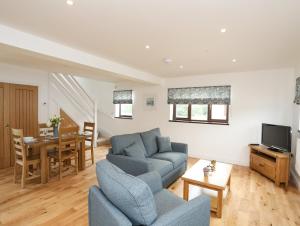 uma sala de estar com um sofá e uma mesa em Bwthyn Cae Haidd em Beaumaris