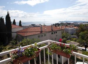 uma varanda com flores e vista para a cidade em Apartment Firule Sandy Beach em Split