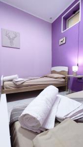 a room with three beds and a purple wall at Apartment's - 500 mt Pompeii Ruins-Vesuvio in Pompei