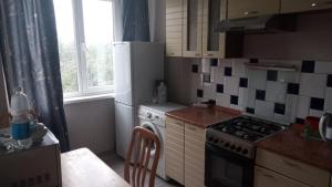uma pequena cozinha com um fogão e um lavatório em Apartment Shevchenko Panfilova em Almaty