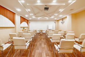 a conference room with white chairs and a podium at Shato City in Nizhny Novgorod