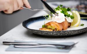 una persona comiendo un plato de comida con un tenedor en The Cottage en Willington