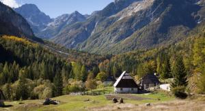 a house on a hill with mountains in the background at Počitniška HIŠKA POLOVNIK in Bovec