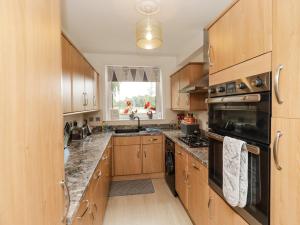 a kitchen with wooden cabinets and a sink at Simply Suite in Castle Douglas