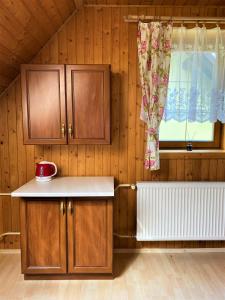 a kitchen with wooden cabinets and a window at Vila Diana in Ždiar