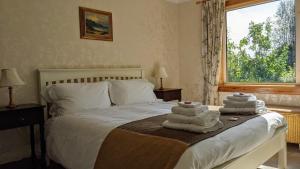 a bedroom with a bed with towels on it at Remuera, North Tolsta in North Tolsta