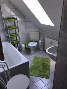ein Badezimmer mit einer Badewanne, einem WC und einem Waschbecken in der Unterkunft Ferienhaus Zur Heide - Obergeschoss in Radibor