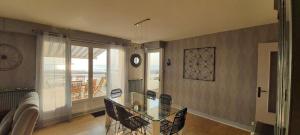 a dining room with a glass table and a balcony at Superbe appartement avec terasse face à la mer in Boulogne-sur-Mer