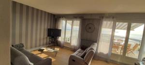 salon z kanapą i telewizorem w obiekcie Superbe appartement avec terasse face à la mer w mieście Boulogne-sur-Mer