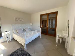 a bedroom with a white bed and a desk at Villa Vittoria in Erba