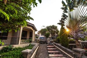 a pathway leading to a house with a palm tree at The Lahe Hotels in Mwanza