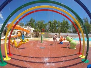 a boy is playing in a water park at MobileHome 8 Personnes avec Clim situé aux Sables du Midi in Valras-Plage