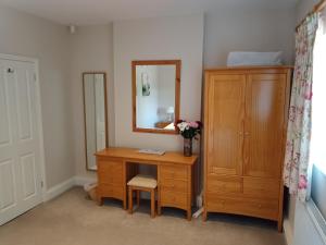 Oak End Lodge في سيفينوكس: غرفة بها مكتب ومرآة وخزانة