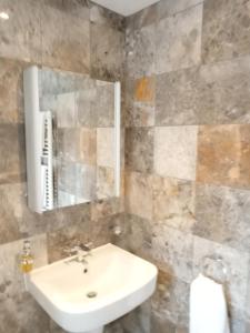 a bathroom with a sink and a mirror at Oak End Lodge in Sevenoaks