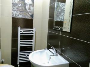een badkamer met een wastafel en een spiegel bij Къща за гости "Тони" in Dobrinishte