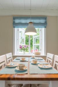 a dining room with a table with chairs and a window at Altes Schulmeisterhaus Wohnung 2 in Oevenum