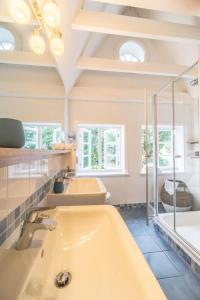a bathroom with two sinks and a tub at Altes Schulmeisterhaus Wohnung 2 in Oevenum
